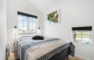 Un dormitorio con una cama con un gato acostado en ella. en Holiday Home Anker Eskildsensvej Hvide Sande Vi, en Nørre Lyngvig 23 fotos más