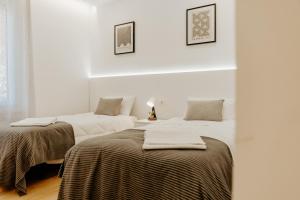 deux lits dans une chambre aux murs blancs dans l'établissement Apartamento Logroño Central Home, à Logroño