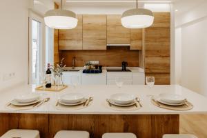 une cuisine avec des comptoirs blancs et des murs en bois dans l'établissement Apartamento Logroño Central Home, à Logroño 18 autres photos