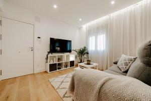 un salon avec un canapé et une télévision à écran plat dans l'établissement Apartamento Logroño Central Home, à Logroño