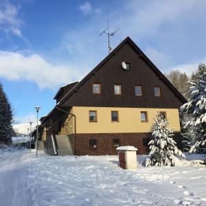 eine große braune und gelbe Scheune im Schnee in der Unterkunft Apartmán V Zeleni in Dolní Morava