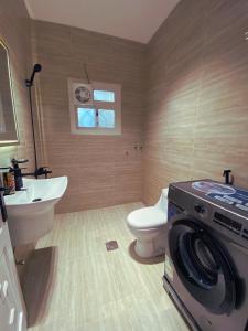 a bathroom with a toilet and a washing machine in it at دار نوره وحدة سكنية في منتصف جدة in Jeddah