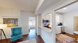 a kitchen with white cabinets and a blue chair in a room at Nashville West End Getaway in Nashville +52 photos
