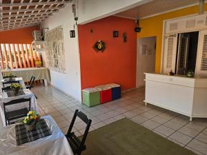 a living room with orange walls and a table and chairs at Hospedagem São Francisco in São Luís +16 photos