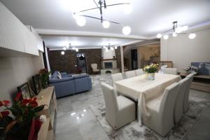 a dining room and living room with a table and chairs at La Ancuța-n Bucovina in Gura Humorului