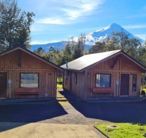 a home with mountains in the background at Cabañas Bachmann in Puerto Varas