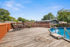 a wooden deck with a pool and a table and chairs at Poolside Palisade - A Fun Family Retreat for 6 in Marquette Heights