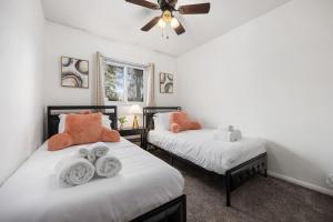 a bedroom with two beds and a ceiling fan at Poolside Palisade - A Fun Family Retreat for 6 in Marquette Heights +33 photos