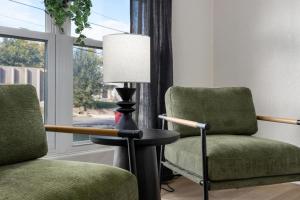 two chairs and a lamp in a room with a window at Hines Haven - Unit 2 - Perfect BNB for YOU in Peoria