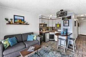 a living room with a couch and a kitchen at Oceanfront Condo Heated Pool Walk to Beach Views in Galveston