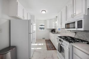 a kitchen with white cabinets and a stove top oven at A Pop of Color - 3BD in the Heights w 3 King Beds in Peoria Heights