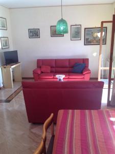 un soggiorno con divano rosso e tavolo di Apartment Trapani a Trapani