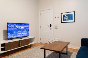 a living room with a flat screen tv on a cabinet at Wicker Park 2BR Modern Apartment DV3 in Chicago