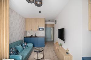 a living room with a couch and a kitchen at miniSTUDIOS URSUS by VAYA STAYS in Warsaw