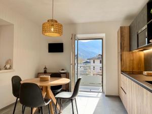 uma cozinha e sala de jantar com mesa e cadeiras em Casa di Maggie 2 - Comfort e natura tra Pinzolo e Campiglio em Carisolo