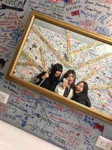 two women taking a picture in front of a mirror at Gloria Hostel Milano in Milan