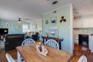 a kitchen and living room with a table and chairs at The Cozy Blue Cottage in Long Beach