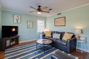a living room with a couch and a tv at The Cozy Blue Cottage in Long Beach