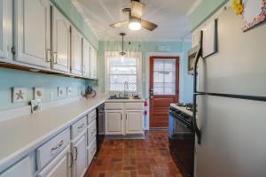 a kitchen with white cabinets and a black refrigerator at The Cozy Blue Cottage in Long Beach +10 photos