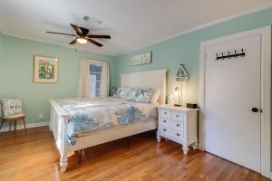 a bedroom with a bed and a ceiling fan at The Cozy Blue Cottage in Long Beach
