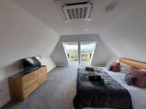 une chambre avec un grand lit et une télévision dans l'établissement Camelot House 1 Bed Duplex Sea View Cabrio Balcony, à Tintagel