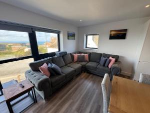 un salon avec un canapé et une table dans l'établissement Camelot House 1 Bed Duplex Sea View Cabrio Balcony, à Tintagel