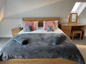 une chambre avec un grand lit avec des oreillers dans l'établissement Camelot House 1 Bed Duplex Sea View Cabrio Balcony, à Tintagel