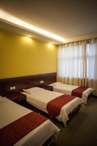 Ένα ή περισσότερα κρεβάτια σε δωμάτιο στο Huangshan Tangkou Haoshi International Youth Hostel