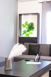 a room with a table with a plant in a window at Etheria Apartment in Artemida