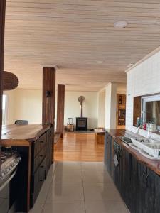 a large kitchen with wooden floors and a large room at Vista Frente al Mar "Travesiaustral-Tunquén" in Valparaíso