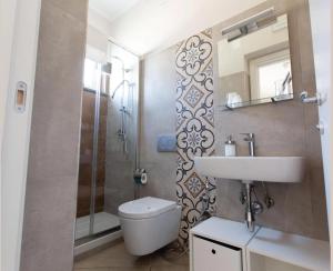 a bathroom with a sink and a toilet and a shower at Crialesi Boutique Rooms in Falerna