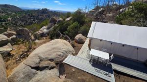 eine Bank auf der Seite eines Berges in der Unterkunft Cozy Mountain View Glamping Tent in De Luz Heights