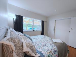 オークランドにあるLakefornt Central Comfort Near Beachのベッドと窓のある寝室