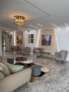 a lobby with couches and tables and a chandelier at Golden Hotel in Vyšší Brod