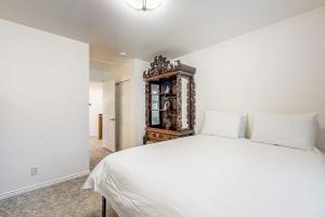 a bedroom with a white bed and a wooden cabinet at Mountain View Retreat - Unit A - Main Home in Park City