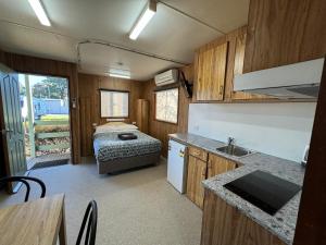 a kitchen and a bedroom with a bed in a trailer at Acacia Caravan Park & Holiday Units in Ararat