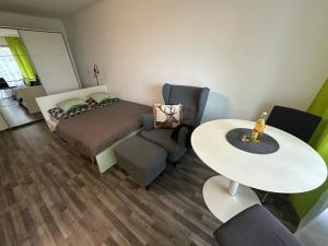 a bedroom with a bed and a table and chairs at Gaishöll-Wasserfälle Apartment Schwarzwald in Sasbachwalden