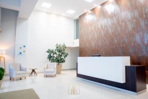 a lobby with two chairs and a reception desk at Departamentos Leloir in Neuquén
