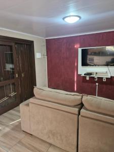 un salon avec un canapé et une télévision à écran plat dans l'établissement Casa aconchego!, à Gramado