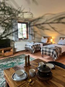 a room with two beds and a table with dishes on it at Ferienhaus Feldblick mit Kamin für 15 Personen in Rüdersdorf