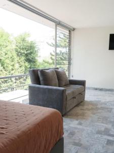 a couch sitting in a room with a large window at Estancia Monraz in Guadalajara