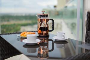 a coffee pot sitting on a table with a plate of food at Departamentos Leloir in Neuquén