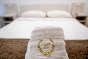 a white bed with a gold heart necklace on it at Departamentos Leloir in Neuquén +185 photos
