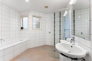 a white bathroom with a sink and a bath tub at Holiday Home Lake Taupo in Taupo +18 photos