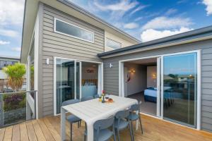 a house with a white table and chairs on a deck at Holiday Home Lake Taupo in Taupo
