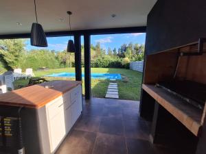a kitchen with a view of a pool and a house at Muana Escobar in Belén de Escobar