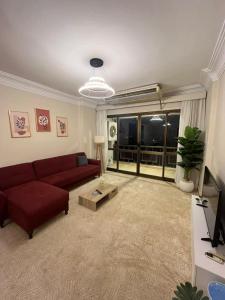 un soggiorno con divano rosso e TV di Zamalek Taha Hussein open view a Il Cairo
