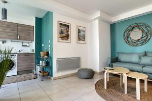 a living room with a blue couch and a table at Centre, lumineux appartement T3 6 Pers Terrasse wifi pkg clim in Antibes