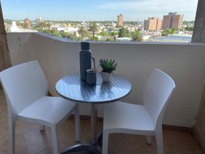een tafel met een fles wijn en twee stoelen bij Departamento Vista Bella, céntrico y cercano a la terminal, Exc ubicación, playa estacionamiento cercana-económica in Villa María