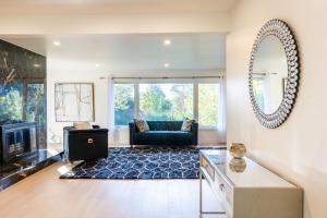 ロンドンにある5 Bedroom Luxury Retreat with Hot Tub and Sauna, Prime Location and More!のソファと鏡のあるリビングルーム